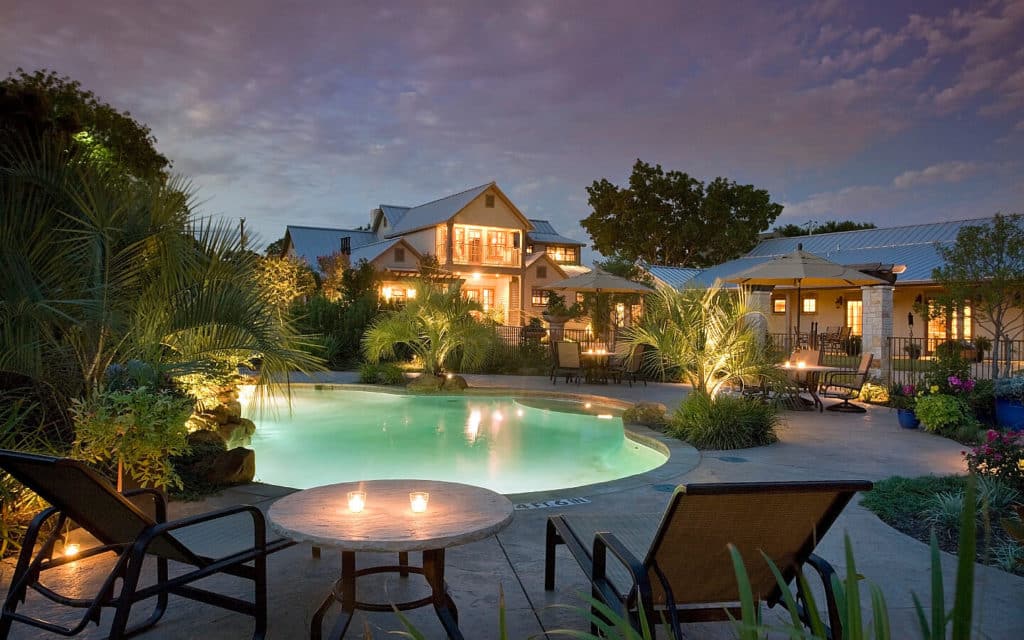 Turquoise waters of the pool against the house and sunset